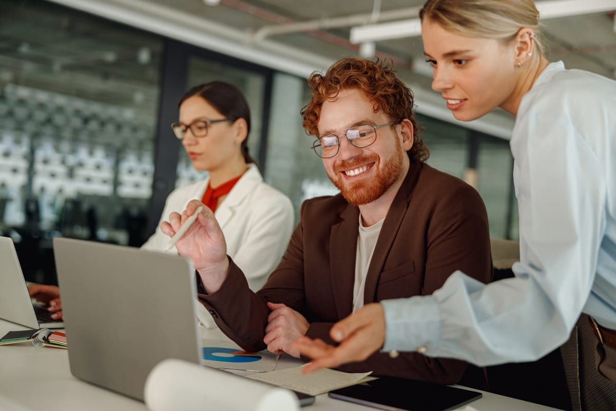 Engaged team collaborating at laptop, representing proactive strategies for building a resilient frontline team