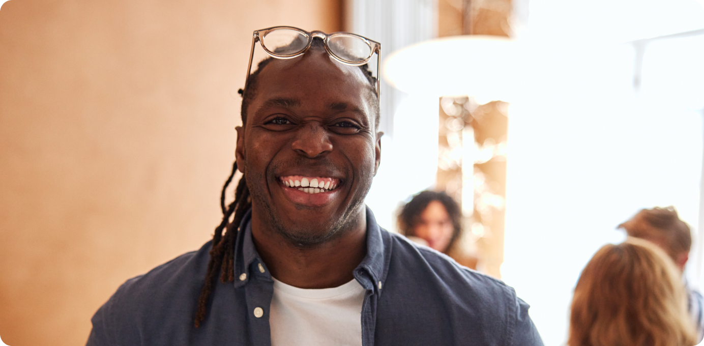Smiling team member in casual office setting, representing a healthy approach to improving frontline performance