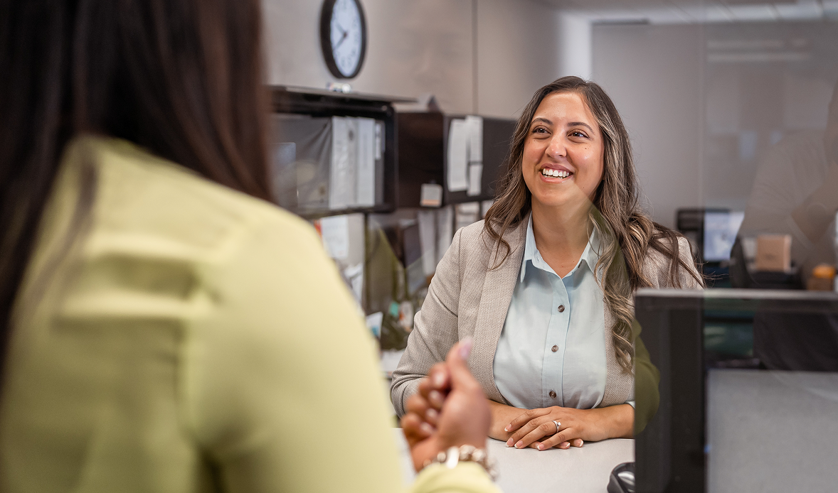 Smiling banker meeting with client across desk, reflecting the CBA Live 2025 focus on building trust in banking