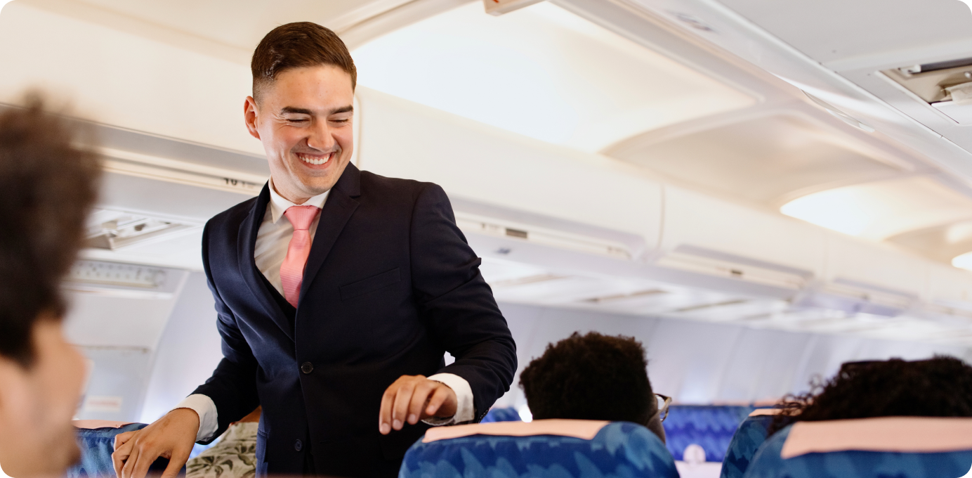 Smiling flight attendant interacting with passengers, demonstrating how frontline staff drive industry-leading CX