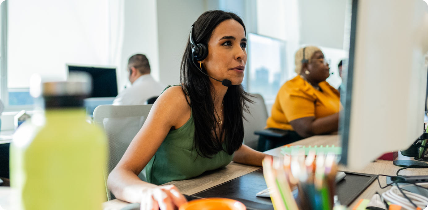 Call center leader focused at computer while supporting team, showing risks of leadership burnout