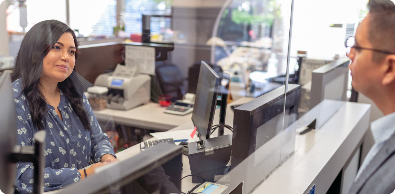 Universal banker assisting a customer at a branch desk, showing personalized service that connects branch and digital experiences.