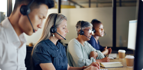 Contact center team on headsets handling complex cases, illustrating AI call deflection effects on workload and focus.